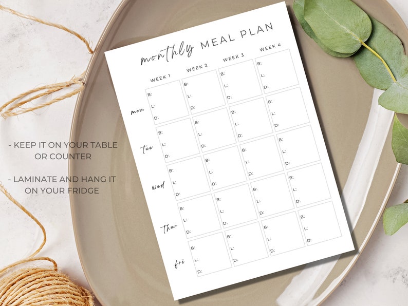 May include: A printable monthly meal planner with a simple design. The planner is divided into four weeks and includes spaces for breakfast, lunch, and dinner for each day of the week. The text "Keep it on your table or counter" and "Laminate and hang it on your fridge" is included.