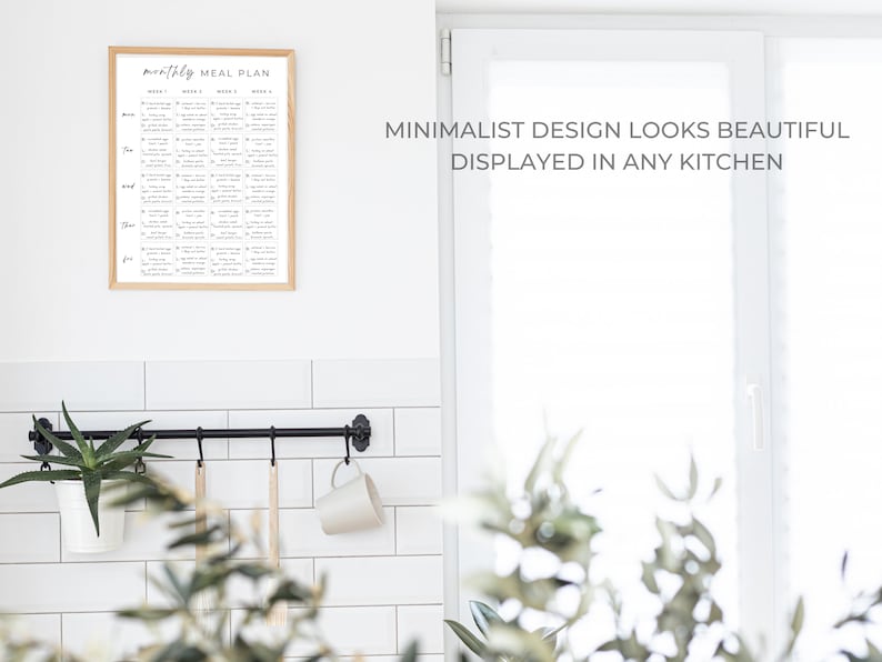 May include: A black metal kitchen utensil rack with hooks hanging on a white tiled wall. A white mug hangs from one hook, and two wooden spoons hang from other hooks. A potted plant sits on a shelf below the rack. A framed printable with the text "monthly meal plan" is hanging on the wall above the rack. The text "MINIMALIST DESIGN LOOKS BEAUTIFUL DISPLAYED IN ANY KITCHEN" is printed on the wall to the right of the rack.