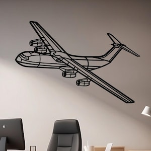 May include: A black metal airplane wall art piece. The artwork depicts a detailed outline of a large aircraft with wings, engines, and a tail. The plane is mounted on a white wall in an office setting, above a desk and chair.