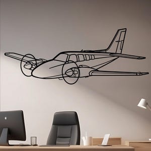 May include: Black line drawing of a twin-engine airplane with propellers, mounted on a light gray wall. The aircraft is depicted in a side view, showcasing its wings, fuselage, and tail. The image is a minimalist design, suitable for aviation enthusiasts.