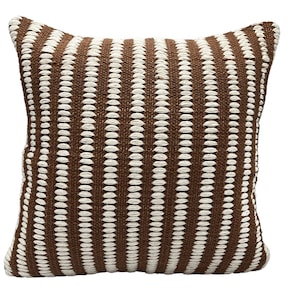 May include: A brown and white striped throw pillow with a textured woven design.