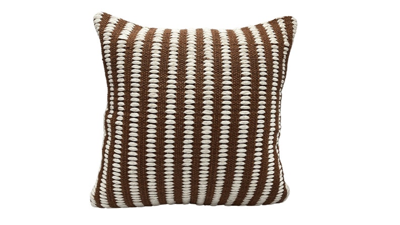 May include: A brown and white striped throw pillow with a textured woven design.