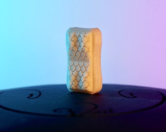May include: A white rectangular chew toy with a textured surface. The toy is sitting on a black surface.