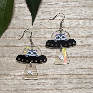 Cosmic Trash Collectors, UFO Raccoon Abduction Earrings, Novelty Trash Panda Fishbone Acrylic Earrings, Clip-ons, or Tunnels