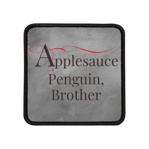 Puede incluir: Un parche cuadrado gris con un diseño rojo y negro. El texto en el parche dice "Applesauce Penguin, Brother".