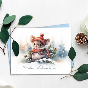 K&ouml;nnte beinhalten: Eine Weihnachtskarte in Aquarelltechnik mit einer niedlichen Maus, die einen roten Hut und Schal tr&auml;gt und in einem verschneiten Wald steht. Die Karte tr&auml;gt den Schriftzug "Frohe Weihnachten".