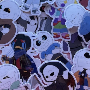 May include: A collection of die-cut vinyl stickers featuring various cartoon skeleton characters in different outfits and poses. The characters include figures with blue scarves, dark hoods, colourful jackets, and one with the word ERROR printed on clothing.