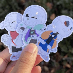 Three skeletons. The one on the left is holding his hand out in a wave, the one in the middle is blowing a kiss, and the one on the right is looking up at the sky.
