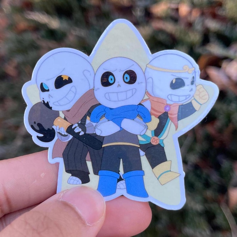 A sticker of three skeletons all posing in front of a yellow star.