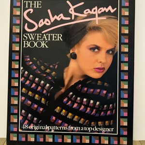 May include: The Sasha Kagan Sweater Book featuring a colourful sweater design on the cover and a woman wearing a black headband and a black sweater with a colourful pattern. The text on the cover reads "The Sasha Kagan Sweater Book" and "48 original patterns from a top designer".