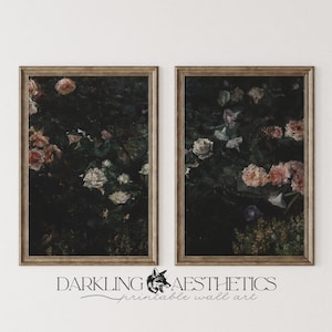 Peut inclure: Deux impressions encadrées d'arrangements floraux sombres avec des fleurs roses, blanches et violettes. Les impressions sont dans des cadres dorés et sont accrochées à un mur blanc.