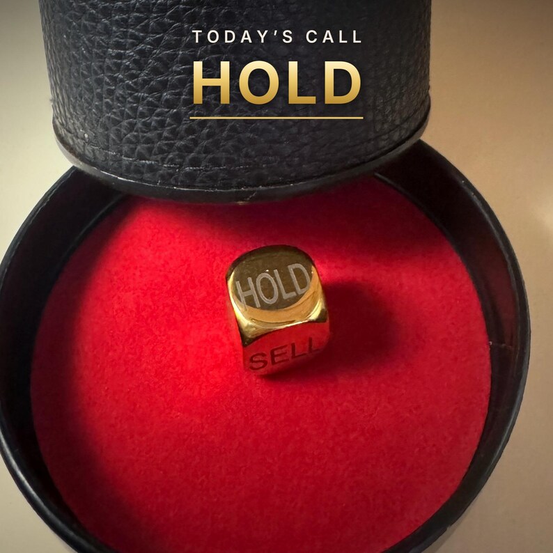 K&ouml;nnte beinhalten: Ein goldfarbener W&uuml;rfel mit den eingravierten W&ouml;rtern HOLD und SELL, der in einem runden schwarzen Beh&auml;lter mit leuchtend rotem Innenraum liegt. Der Deckel des Beh&auml;lters zeigt den Text TODAY'S CALL HOLD in goldener Schrift.