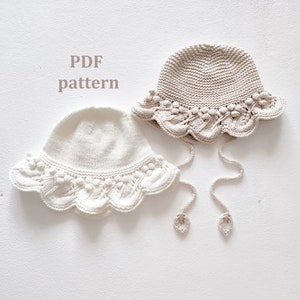 May include: Two crocheted hats with a scalloped brim and a tied bow. The hats are in white and beige.