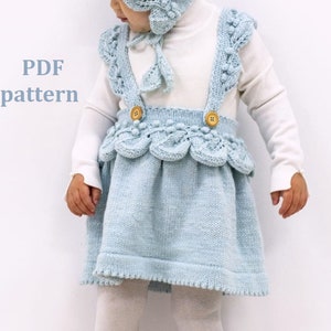May include: PDF pattern for a light blue knitted skirt with a scalloped hem and a white knitted top with a matching hat. The skirt has a button closure and straps.