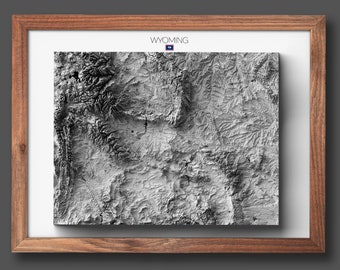 May include: A framed black and white topographic map of Wyoming. The map is framed in a brown wood frame. The state flag of Wyoming is in the upper right corner of the frame.