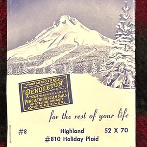 Pu&ograve; includere: Un'etichetta vintage di Pendleton Woolen Mills con una scena di montagna innevata. L'etichetta recita "Warranted to be a Pendleton" e "100% Virgin Wool". &Egrave; presente anche il testo "for the rest of your life". Dimensioni: 132 x 178 cm.