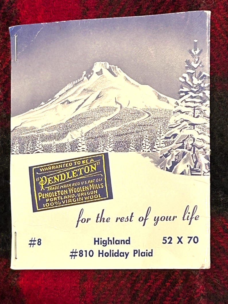 Pu&ograve; includere: Un'etichetta vintage di Pendleton Woolen Mills con una scena di montagna innevata. L'etichetta recita "Warranted to be a Pendleton" e "100% Virgin Wool". &Egrave; presente anche il testo "for the rest of your life". Dimensioni: 132 x 178 cm.