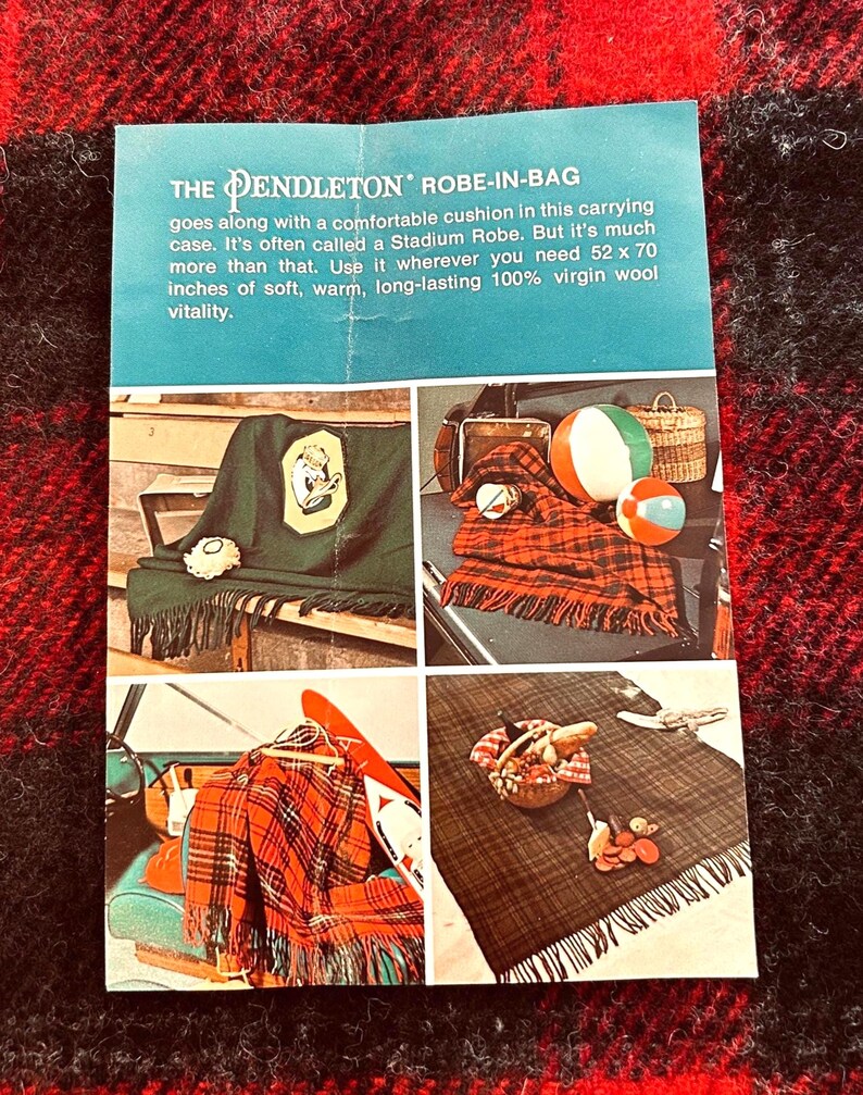 Pu&ograve; includere: Annuncio vintage per un Robe-in-Bag Pendleton, descritto come una coperta da stadio in 100% lana vergine, misura 132 x 178 cm. L'immagine mostra la coperta in vari contesti, tra cui un picnic.