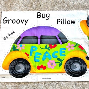 May include: A fabric panel for a Groovy Bug Pillow featuring a lime green car with a purple roof, yellow fenders, and black wheels. The car has the word PEACE in blue letters, floral accents, and the text Groovy Bug Pillow and So fun!