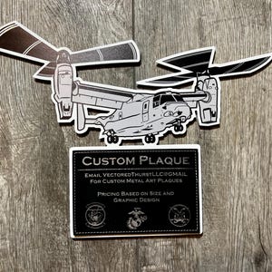 May include: A black and white illustration of a V-22 Osprey tiltrotor aircraft. The image is on a custom metal plaque with the text "CUSTOM PLAQUE", "EMAIL VECTORED THURSTLLC@GMAIL FOR CUSTOM METAL ART PLAQUES", and "PRICING BASED ON SIZE AND GRAPHIC DESIGN".