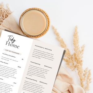 May include: A close-up of a printed document with the title "Tidy Home" and a list of packages and services for home organization. The document is on a white surface with a cup of coffee and a dried flower arrangement.