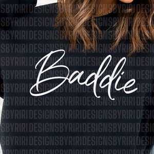 May include: Black sweatshirt with the word "Baddie" written in white cursive script.