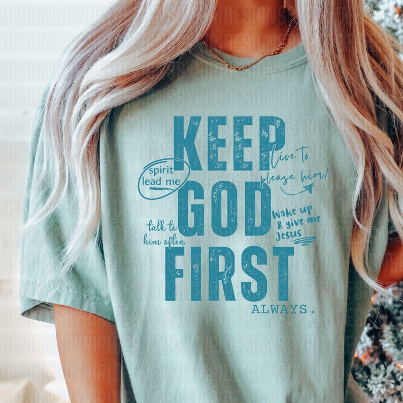 May include: A light green t-shirt with a blue graphic that says "Keep God First Always". The graphic also includes the phrases "spirit lead me", "talk to him often", "live to please him", and "wake up & give me Jesus".