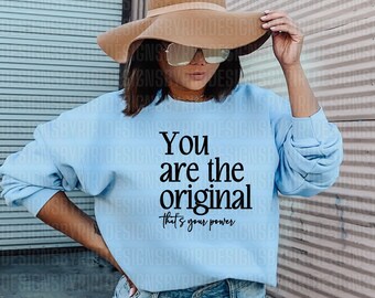 Puede incluir: Una sudadera azul claro con el texto "You are the original that's your power" impreso en negro.