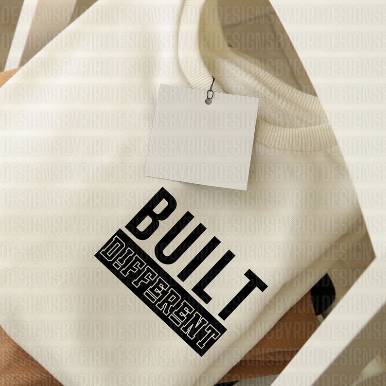 May include: A white sweatshirt with the text "BUILT DIFFERENT" printed in black on the front.