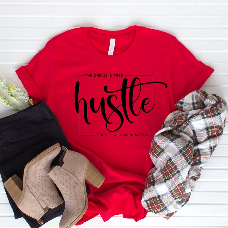 May include: Red t-shirt with the text "The dream is free hustle hustle sold separately" in black lettering.