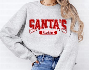 May include: A grey sweatshirt with red text that reads "SANTA'S FAVORITE".