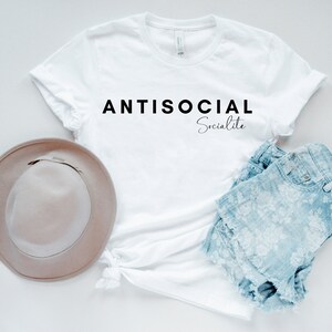 May include: White t-shirt with the text "ANTISOCIAL Socialite" printed in black.