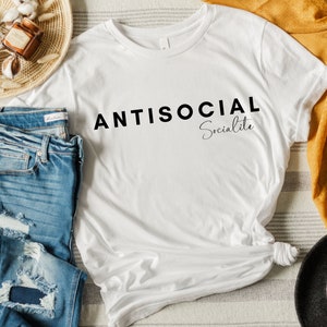 May include: White t-shirt with black text that reads "ANTISOCIAL Socialite".