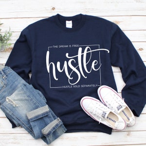 May include: A navy blue sweatshirt with the text "The dream is free hustle hustle sold separately" in white lettering.
