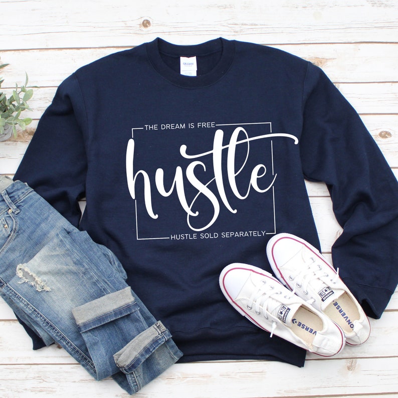 May include: A navy blue sweatshirt with the text "The dream is free hustle hustle sold separately" in white lettering.