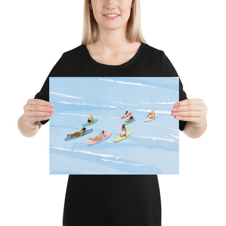 Puede incluir: Una ilustraci&oacute;n de acuarela de un grupo de personas en tablas de surf en el oc&eacute;ano. El agua es azul y el cielo es blanco. Las personas llevan todas trajes de ba&ntilde;o y est&aacute;n remando en sus tablas.