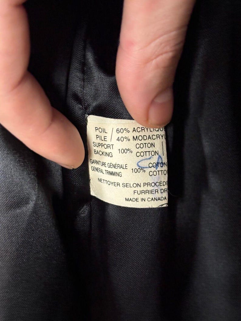 Puede incluir: Una etiqueta de tela blanca con texto negro que detalla la composici&oacute;n de una prenda. La etiqueta dice: "POIL/60% ACRYLIQUE PILE/40% MODACRYL COTON SUPPORT 100% COTTON, GARNITURE G&Eacute;N&Eacute;RALE 100% COTON GENERAL TRIMMING COTTO NETTOYER SELON PROCEDE FURRIER DR MADE IN CANADA"