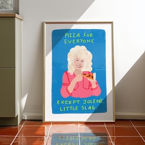May include: A framed rectangular art print featuring a blue background with a central illustration of a blonde person in a pink shirt holding a slice of pizza. The text reads PIZZA FOR EVERYONE EXCEPT JOLENE. LITTLE SLAG. in bright green letters.