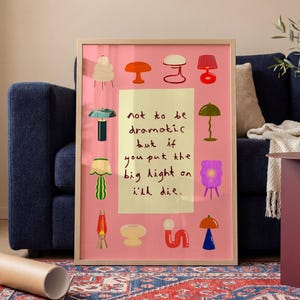 May include: A rectangular framed wall art print with a pink background featuring a central pale yellow rectangle containing the black handwritten text: not to be dramatic but if you put the big light on i'll die. Surrounded by twelve colorful lamps.