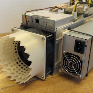 May include: A silver and black cryptocurrency mining machine with a white, spiky fan shroud. The device has multiple fans, power supply, and various ports. The Bitmain logo is visible on the side.