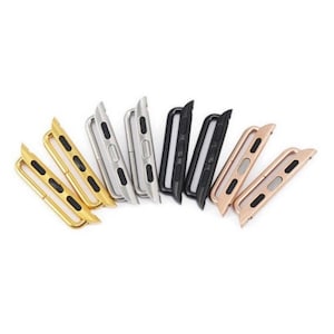 May include: A set of eight metal watch band adapters in gold, silver, black, and rose gold. The adapters are designed to connect a watch band to a watch.