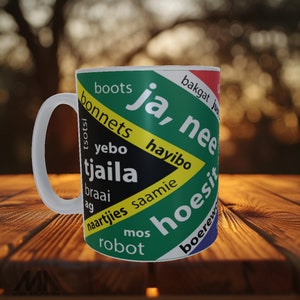 Puede incluir: Taza de cerámica blanca con un diseño colorido que presenta palabras sudafricanas y los colores de la bandera sudafricana. Las palabras en la taza incluyen "ja", "nee", "hayibo", "tsotsi", "yebo", "tjaila", "braai", "ag", "naartjies", "saamie", "hoesit", "bonnets", "boots", "mos", "robot", "bakgat" y "boerewors".