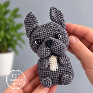 Può includere: Un giocattolo all'uncinetto a forma di bulldog francese grigio scuro con grandi orecchie a punta, occhi in plastica nera, naso nero e una piccola macchia bianca sul petto. L'immagine include un grafico circolare bianco con il testo PDF pattern ONLY.