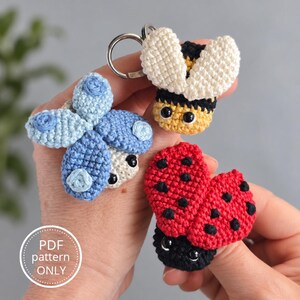 Peut inclure: Trois porte-clés amigurumi au crochet représentant un papillon bleu à pois bleu clair, une abeille jaune et noire aux ailes crème et une coccinelle rouge à pois noirs. Chaque créature a des yeux de sécurité noirs. Texte : PDF pattern ONLY.