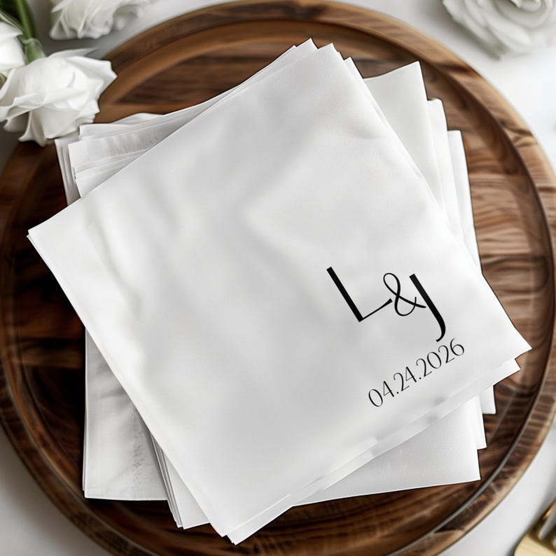 White napkins stacked on a wooden tray with "L&J" and "04.24.2026" printed.