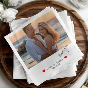 May include: White wedding thank you card with a photo of a couple on a beach at sunset. The card has red hearts and the text "Thank you" and "Chris & Jessica 09.09.24".