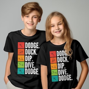 以下が含まれることがあります： カラフルなグラフィックデザインが施された黒いTシャツを着た子供2人。グラフィックには「Dodge. Duck. Dip. Dive. Dodge.」という文字と、各アクションの棒人間イラストが描かれています。