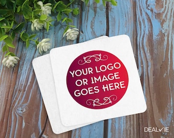 May include: Two square white coasters featuring a central circular design with a red to purple gradient background. The text "YOUR LOGO OR IMAGE GOES HERE" is printed in white in the center, accented by decorative white flourishes at the top and bottom.