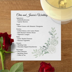 May include: A square wedding menu card titled Chris and Jessica's Wedding Menu, listing appetizers, salad, entr&eacute;es, sides, dessert, and beverages. The white card features a watercolor floral corner design in shades of green and grey.