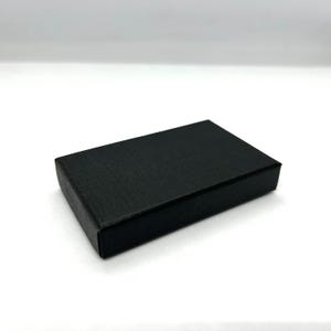 May include: A black rectangular box with a textured surface.